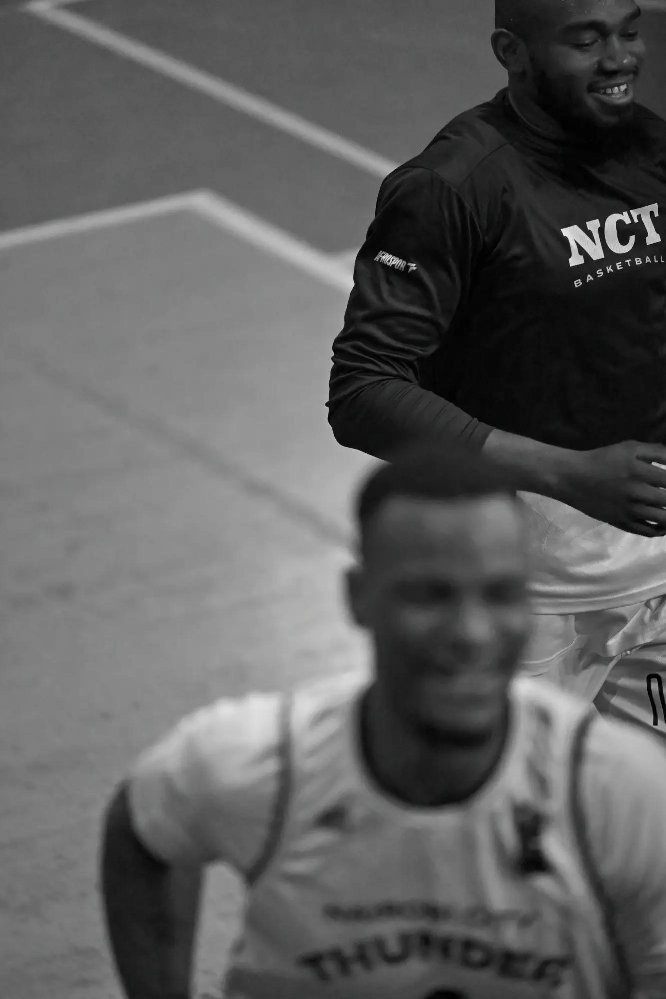 Two Thunder players share a laugh in warm-up, one sharp behind the other's out-of-focus grin