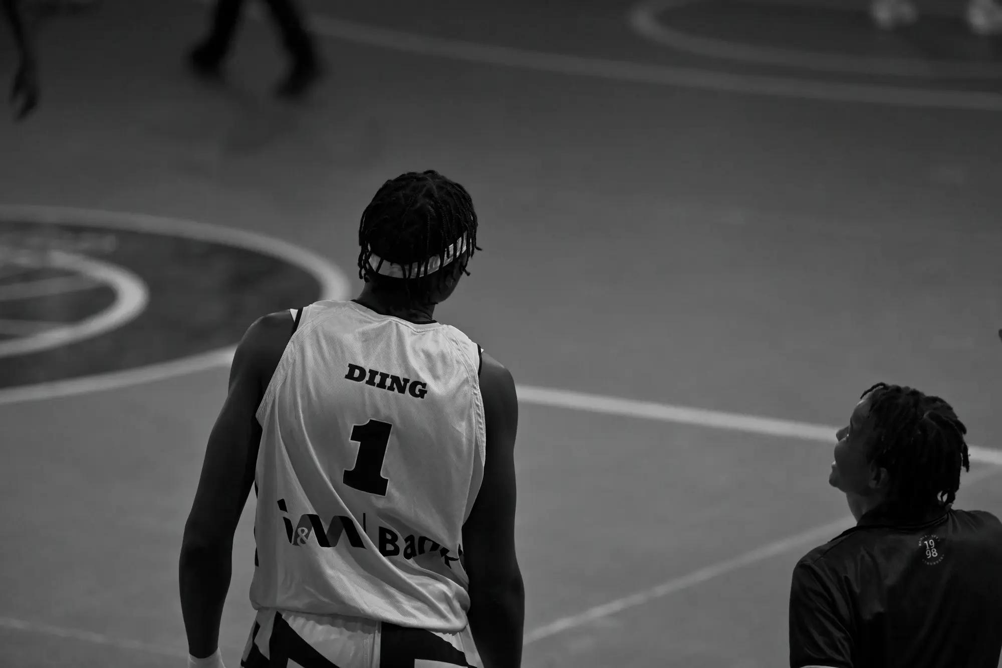 Nairobi City Thunder's number one alone on the painted arc between plays, a teammate glancing up