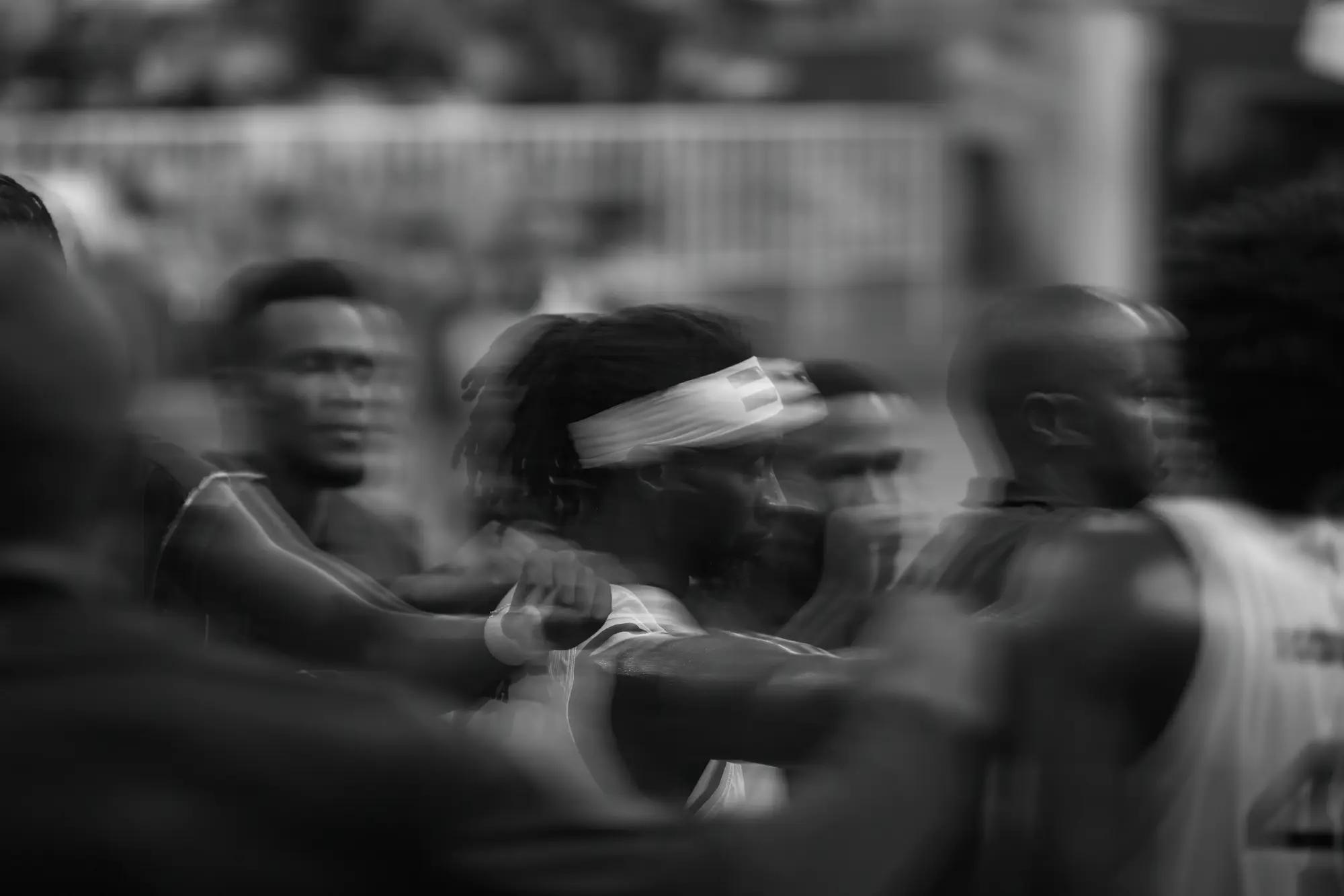 Players lean into a huddle, their faces layered over one another by a long exposure
