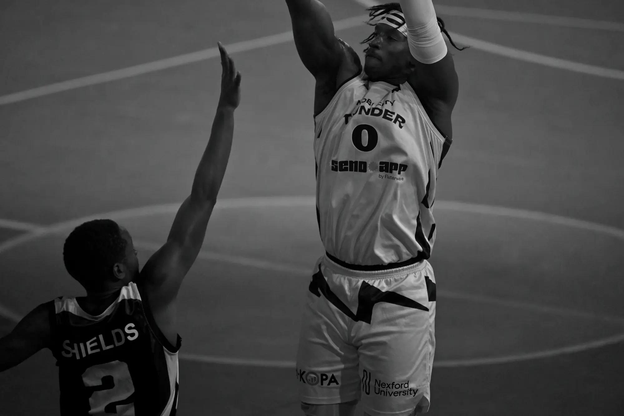 Thunder number zero rises into his jump shot as a Stanbic defender stretches a hand across the frame