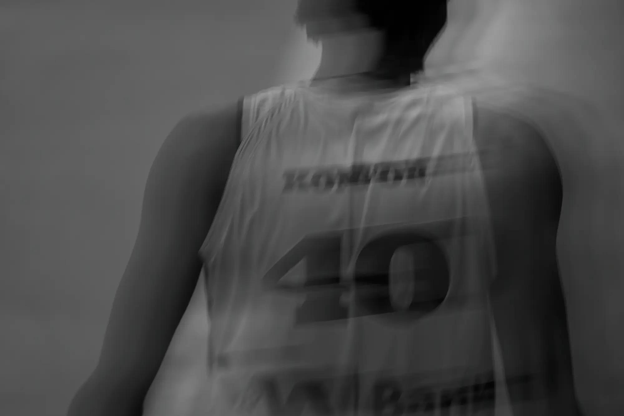 The back of a white number forty jersey smeared into near-abstraction by a twentieth-of-a-second exposure