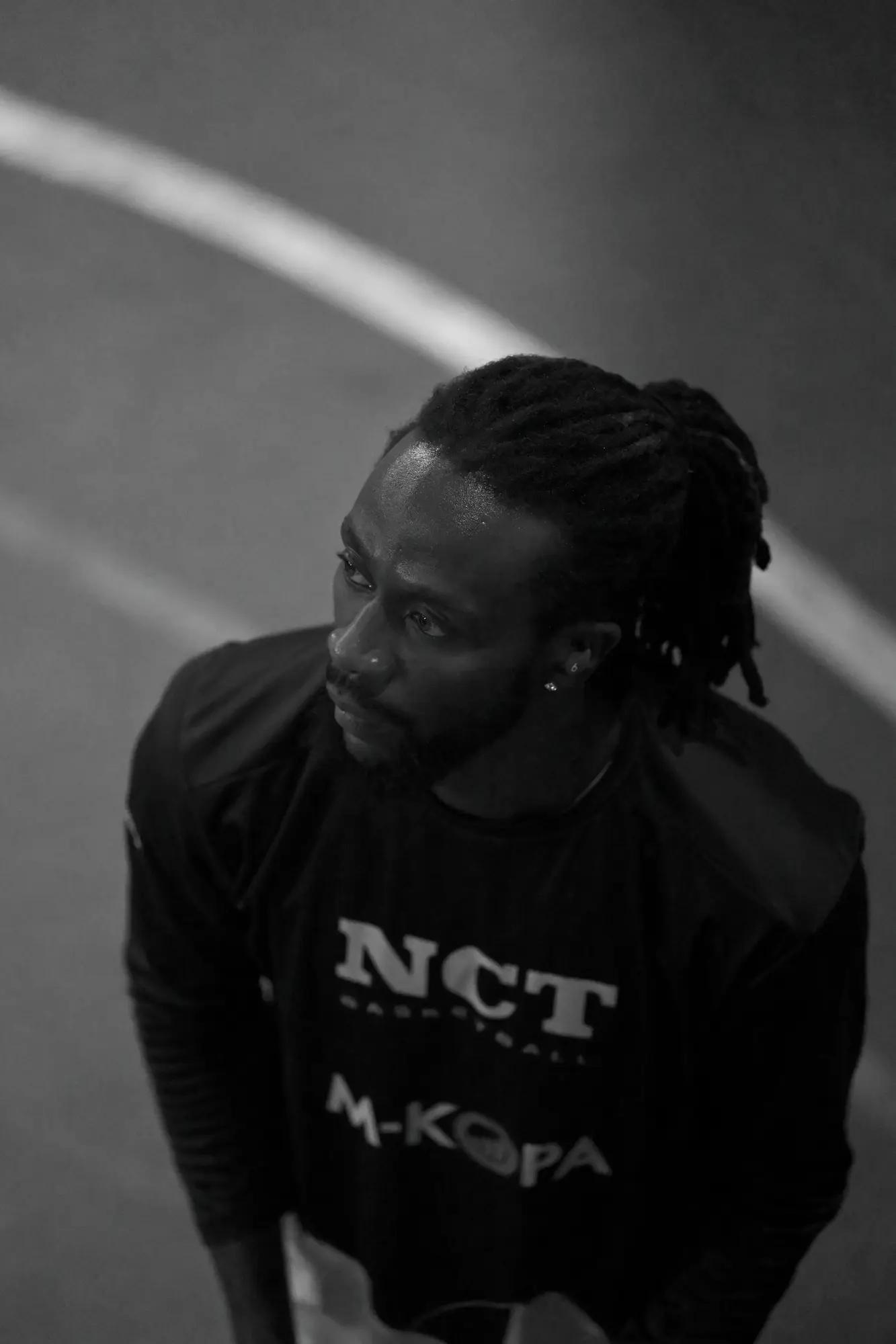 A player in a Thunder warm-up top looks off court, a painted arc curving through the floor behind