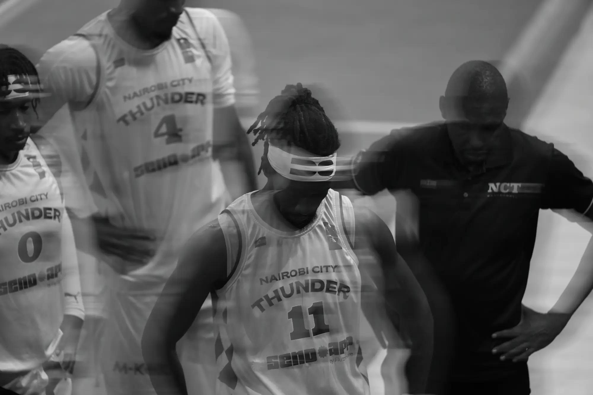 Thunder players and their coach ghost through one another in a huddle, heads bowed